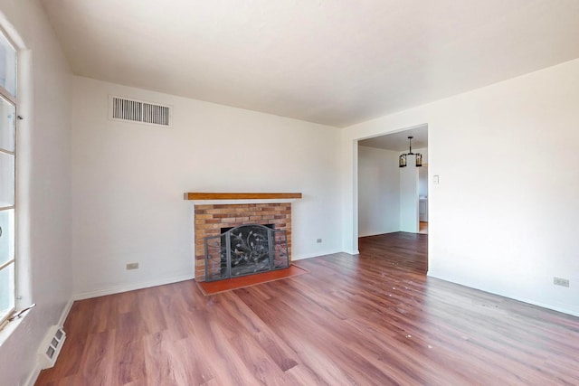 unfurnished living room featuring a fireplace and wood-type flooring