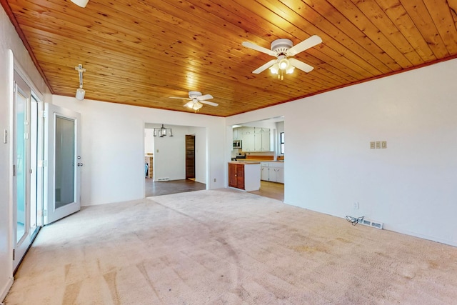 carpeted empty room featuring ceiling fan, a healthy amount of sunlight, and wooden ceiling