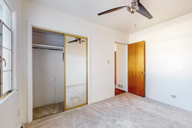 unfurnished bedroom featuring carpet flooring, ceiling fan, and a closet