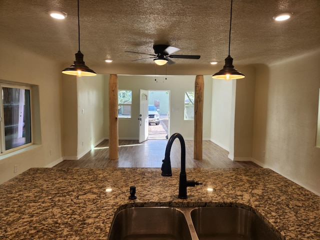 kitchen featuring pendant lighting, ceiling fan, sink, hardwood / wood-style flooring, and a textured ceiling