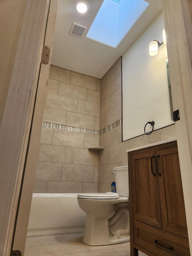 bathroom featuring toilet, a skylight, and a bathtub