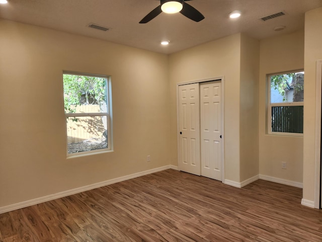 unfurnished bedroom featuring ceiling fan, a closet, and dark hardwood / wood-style flooring