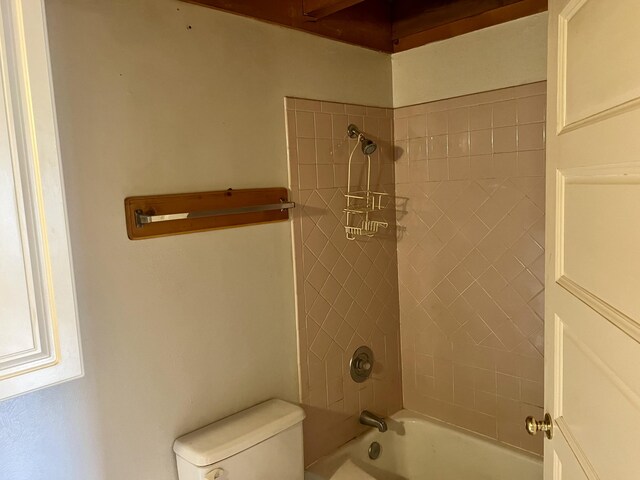 bathroom featuring tiled shower / bath and toilet