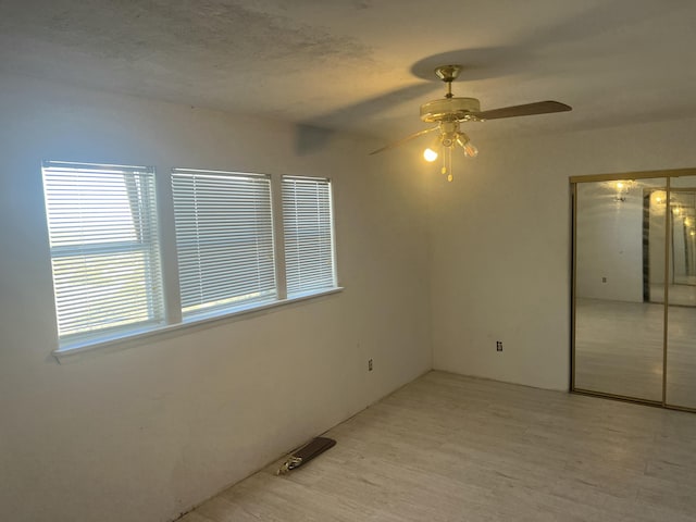 unfurnished bedroom featuring a closet, ceiling fan, and light wood finished floors