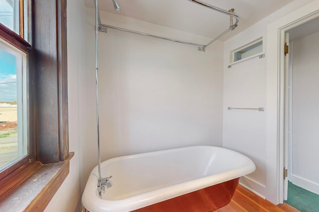 bathroom featuring a tub to relax in and hardwood / wood-style floors