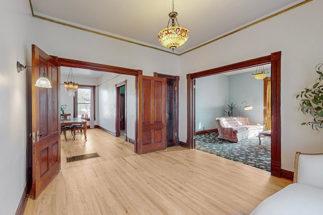 interior space with light hardwood / wood-style floors and ornamental molding