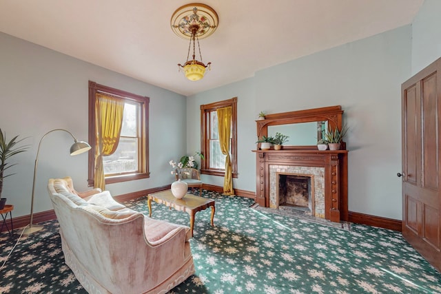 living area with a tiled fireplace and carpet flooring