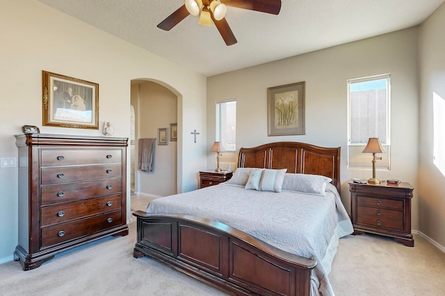 carpeted bedroom featuring a textured ceiling and ceiling fan