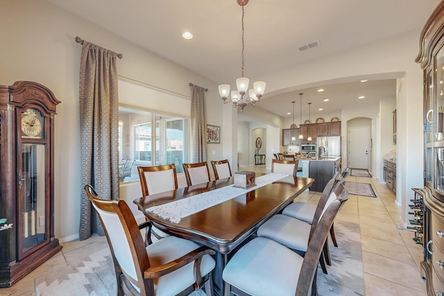 dining area with sink, a notable chandelier, and light tile patterned floors