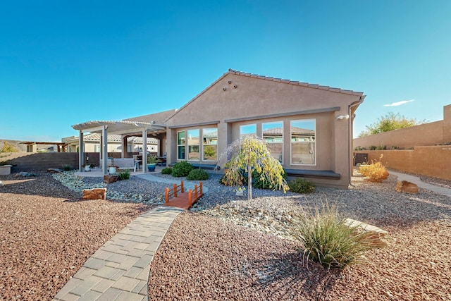 rear view of property with a pergola and a patio area