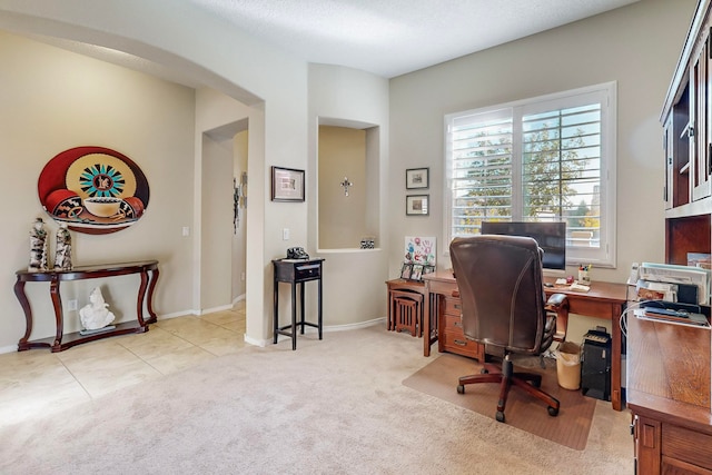 home office with a textured ceiling and light colored carpet