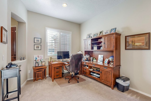 carpeted home office featuring a textured ceiling