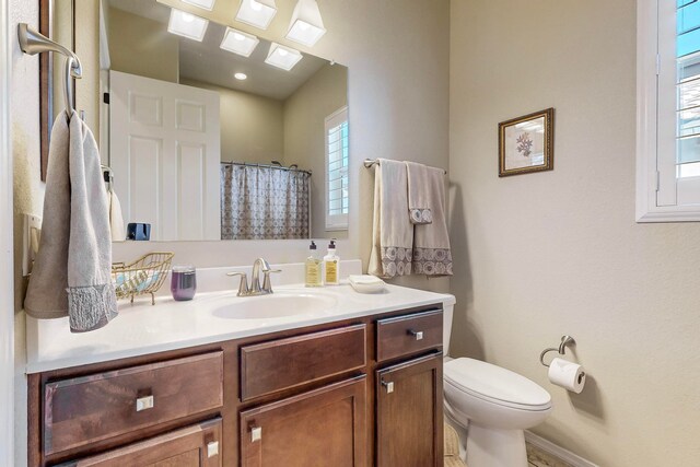 bathroom with vanity, toilet, and plenty of natural light