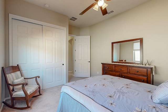 bedroom with a closet, ceiling fan, and light colored carpet