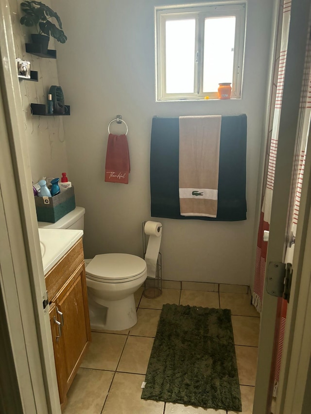 bathroom with toilet, vanity, and tile patterned floors