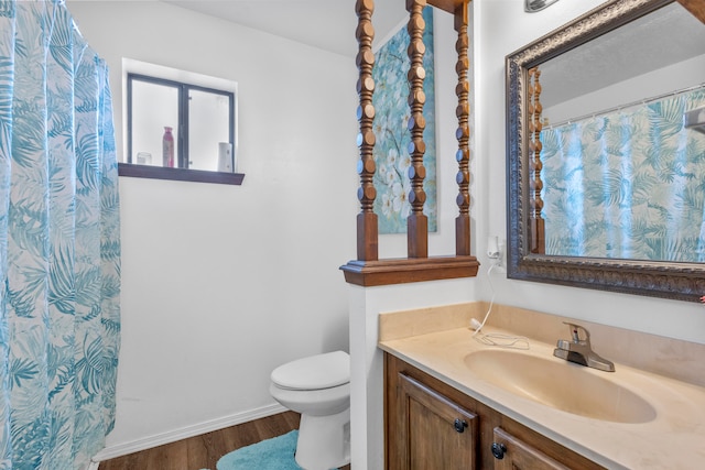 bathroom featuring wood-type flooring, vanity, and toilet