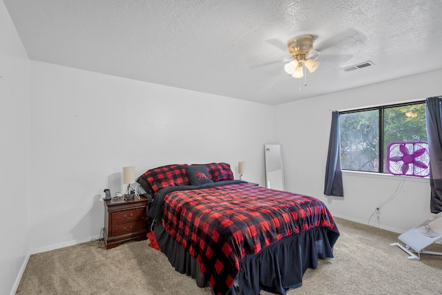 bedroom with ceiling fan, a textured ceiling, and light carpet