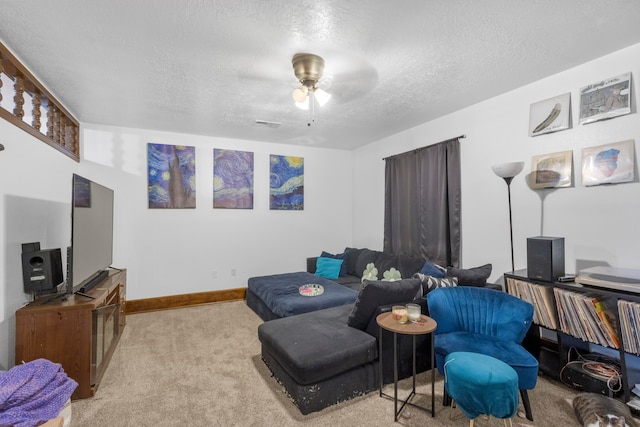 carpeted living room featuring ceiling fan and a textured ceiling