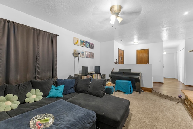 living room featuring a textured ceiling, carpet flooring, and ceiling fan