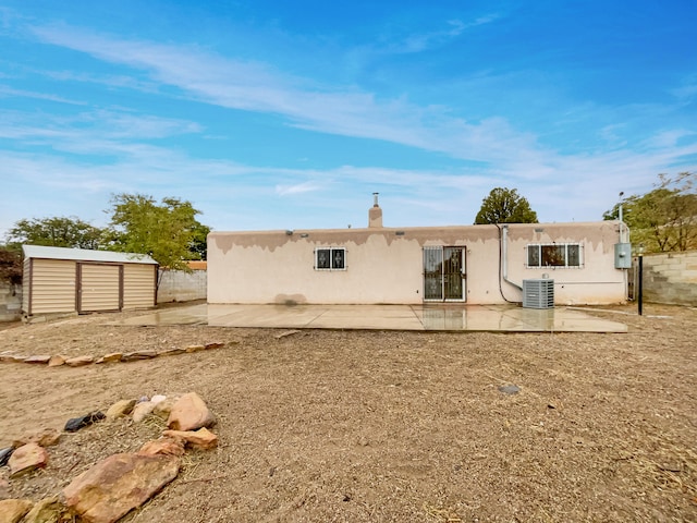 back of property featuring central AC unit, a patio area, and a storage unit