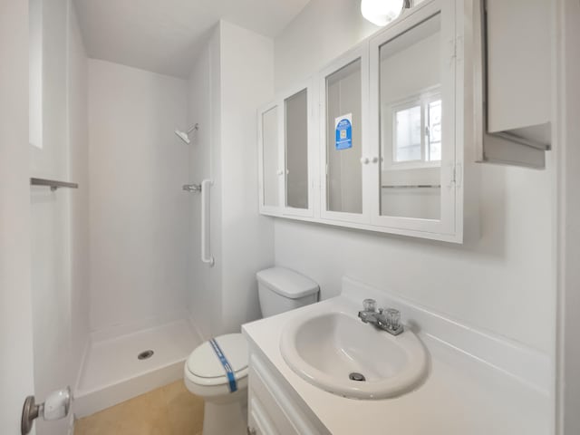 bathroom featuring a shower, tile patterned floors, vanity, and toilet