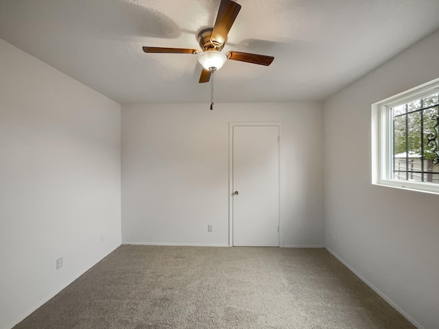 carpeted empty room featuring ceiling fan