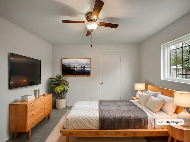 bedroom with ceiling fan and dark carpet