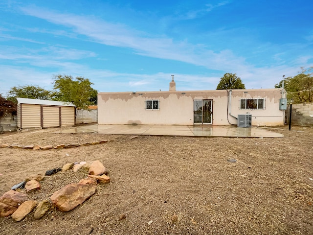 back of property featuring a storage unit, central AC, and a patio area