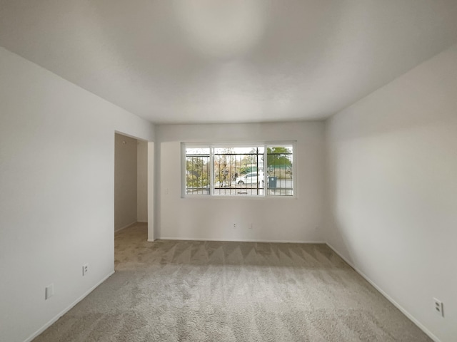 unfurnished room featuring light carpet