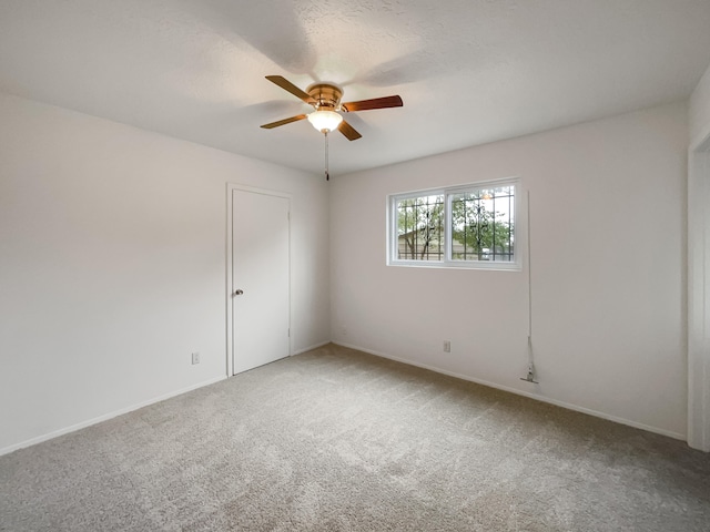 carpeted spare room featuring a textured ceiling and ceiling fan