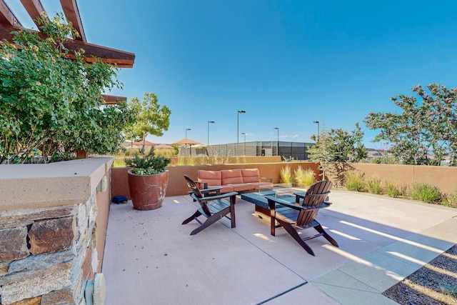 view of patio with an outdoor living space with a fire pit