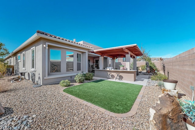 back of property with a yard and a patio area