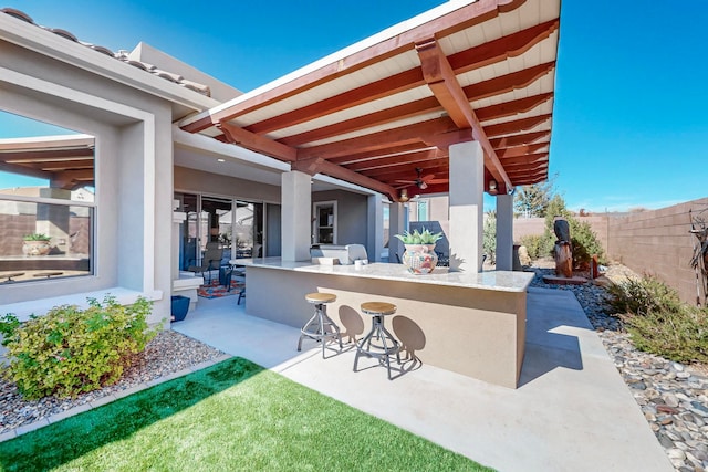 view of patio / terrace with ceiling fan and an outdoor bar