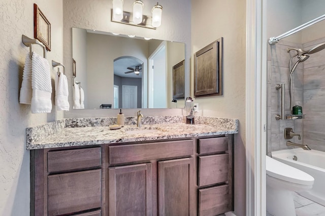 full bathroom featuring toilet, tiled shower / bath combo, vanity, and ceiling fan