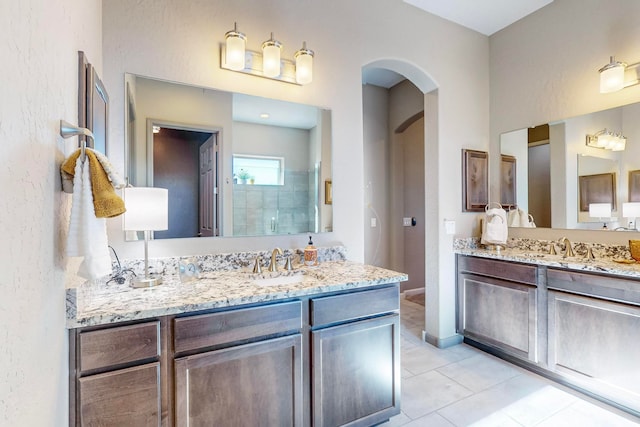 bathroom with tile patterned flooring, vanity, and a shower