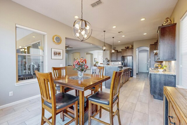 dining room featuring ceiling fan with notable chandelier