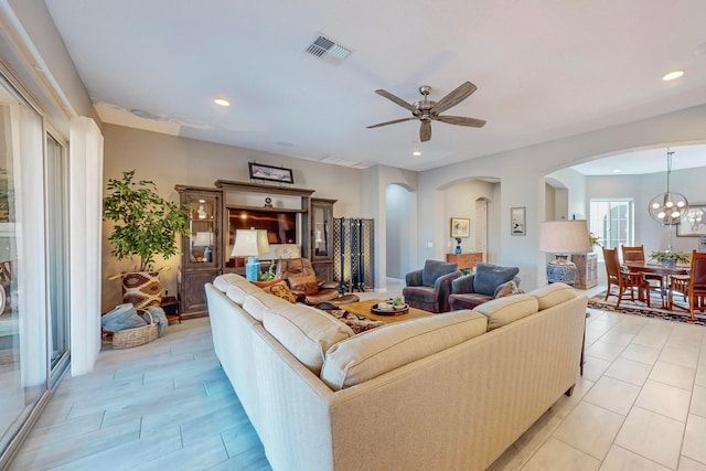 living room featuring ceiling fan with notable chandelier