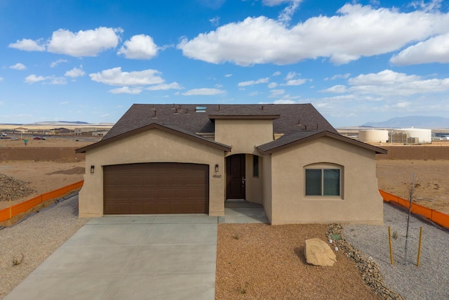 4860 Guadalupe Peak St SW, Los Lunas, NM 87031 - view of front of home featuring stucco siding, an attached garage, concrete driveway, a mountain view, and fence