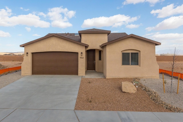 4860 Guadalupe Peak St SW, Los Lunas, NM 87031 - mediterranean / spanish-style house featuring a garage, stucco siding, driveway, fence, and a shingled roof