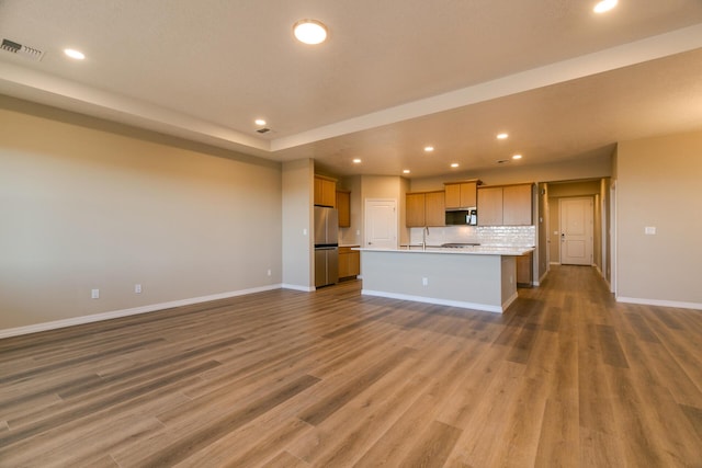 4860 Guadalupe Peak St SW, Los Lunas, NM 87031 - kitchen with appliances with stainless steel finishes, recessed lighting, open floor plan, baseboards, and a center island with sink