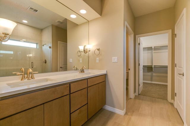 4860 Guadalupe Peak St SW, Los Lunas, NM 87031 - bathroom featuring a shower stall, double vanity, baseboards, and a walk in closet