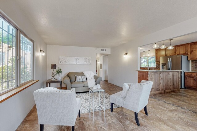 living room featuring sink and a textured ceiling