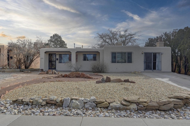 pueblo revival-style home featuring stucco siding