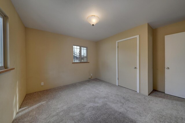 unfurnished bedroom with light colored carpet