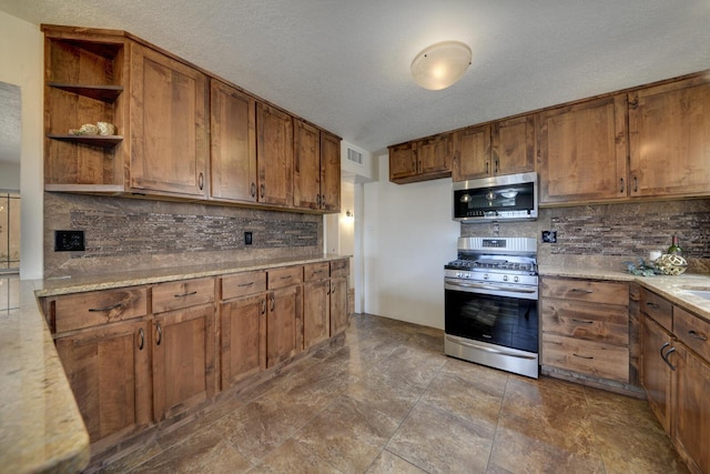 kitchen with backsplash, a textured ceiling, and appliances with stainless steel finishes