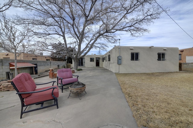 rear view of house with a patio and an outdoor fire pit