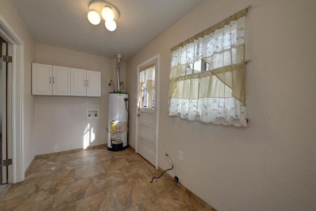 interior space with cabinets, hookup for a washing machine, and gas water heater