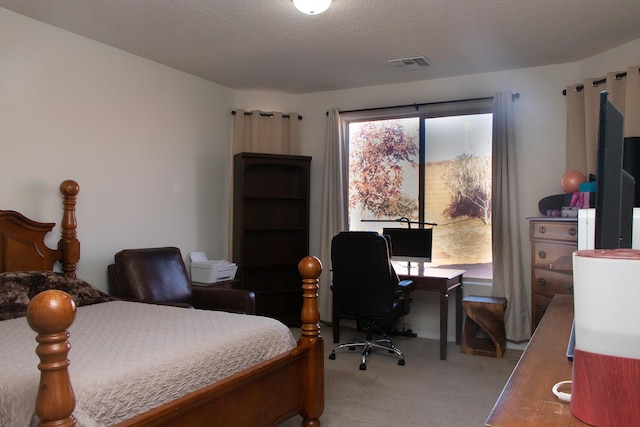 bedroom featuring light colored carpet and a textured ceiling