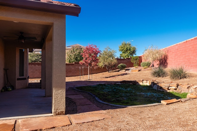 view of yard featuring ceiling fan and a patio