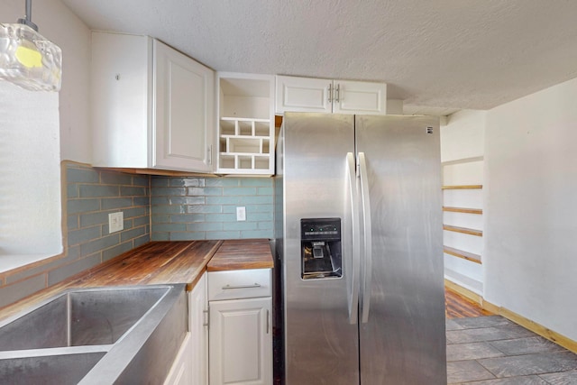 kitchen with dark hardwood / wood-style flooring, white cabinets, stainless steel refrigerator with ice dispenser, hanging light fixtures, and backsplash